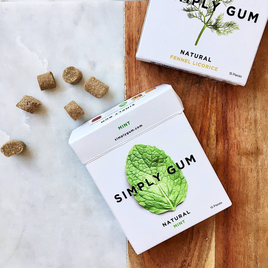 Simply Gum packaging with mint leaf design on a wooden surface