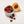 Small white bowl with raspberries and chocolate truffles next to a peach on a light background