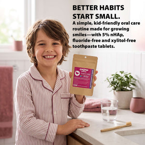 A smiling child in pink striped pajamas holds up a pouch of Chomp Oral Care toothpaste tablets in a bright kitchen setting, with promotional text at the top.