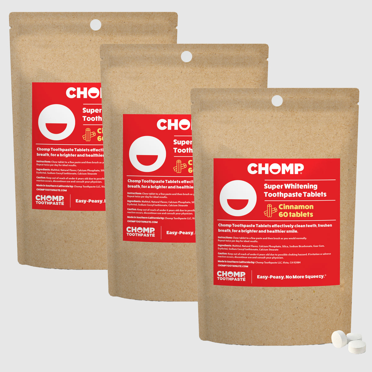 Three packages of CHOMP Super Whitening Toothpaste Tablets on a light gray background
