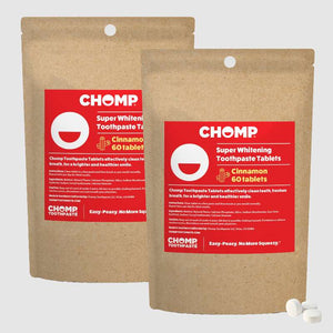 Two packages of CHOMP Super Whitening Toothpaste Tablets with red labels on a light gray background.
