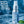 Chomp breath spray bottle with peppermint leaves on a blue background