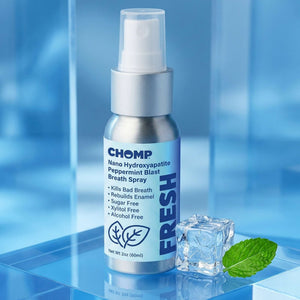 CHOMP breath spray bottle with mint leaf and ice cube on a blue background
