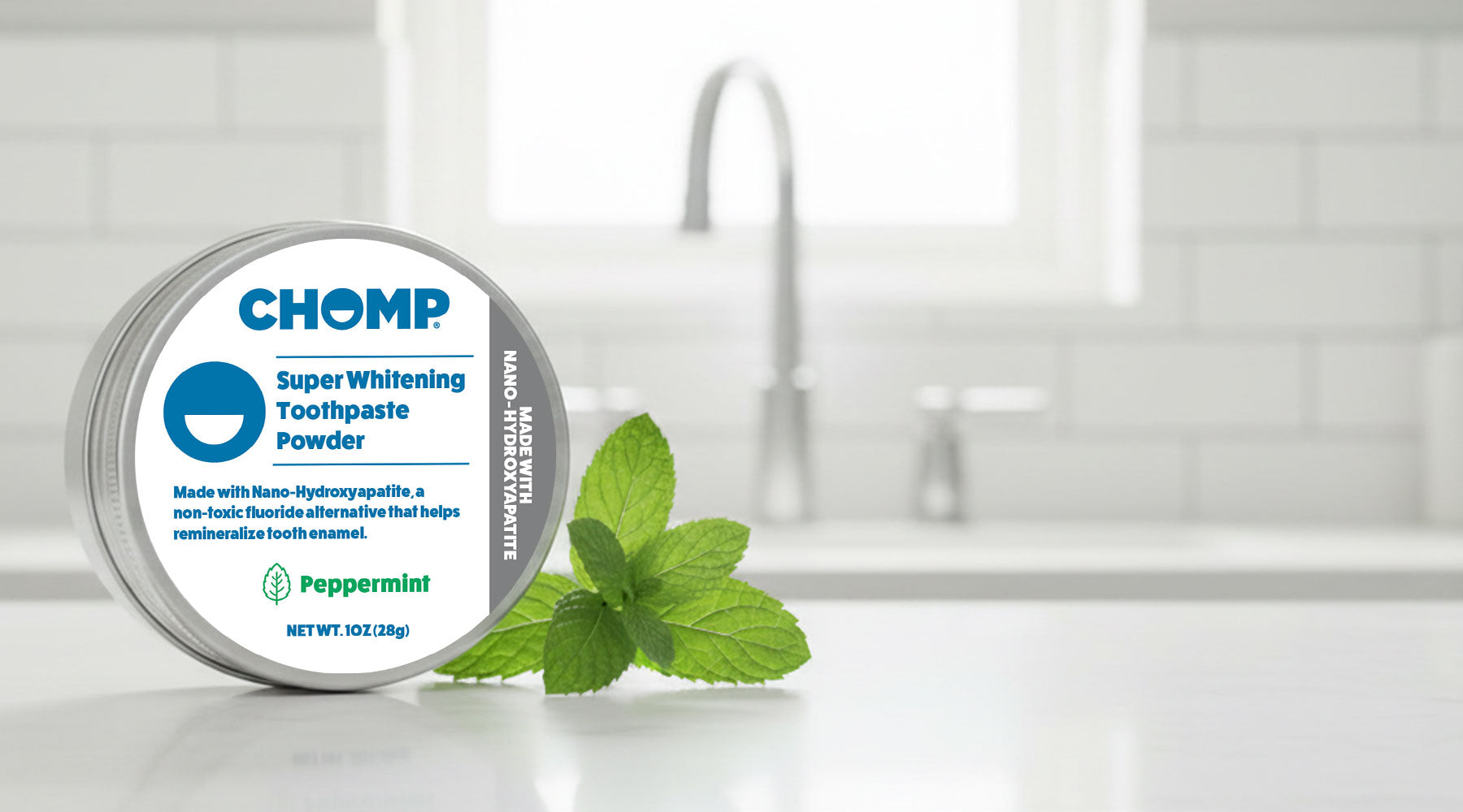 Chomp super whitening toothpaste powder container with peppermint leaves on a kitchen counter.