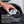 FRESH! gum tin being put into a black backpack by a male.