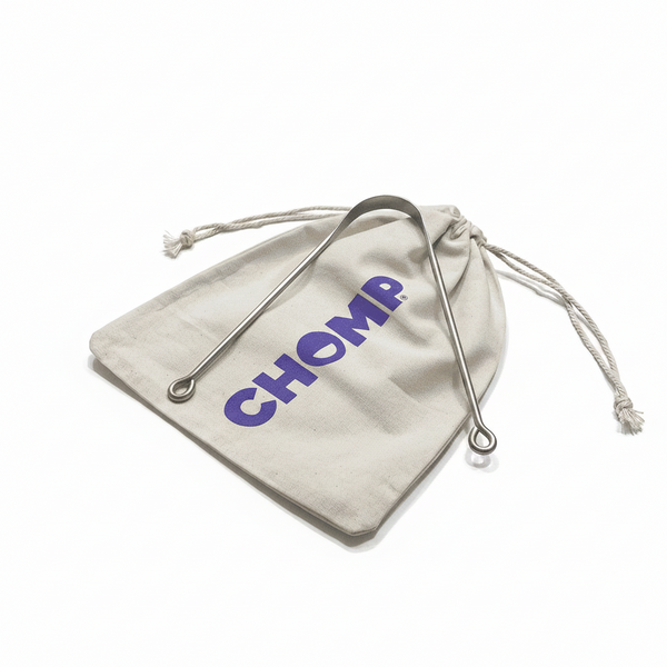 Beige drawstring bag with 'CHOMP' branding on a bathroom counter.