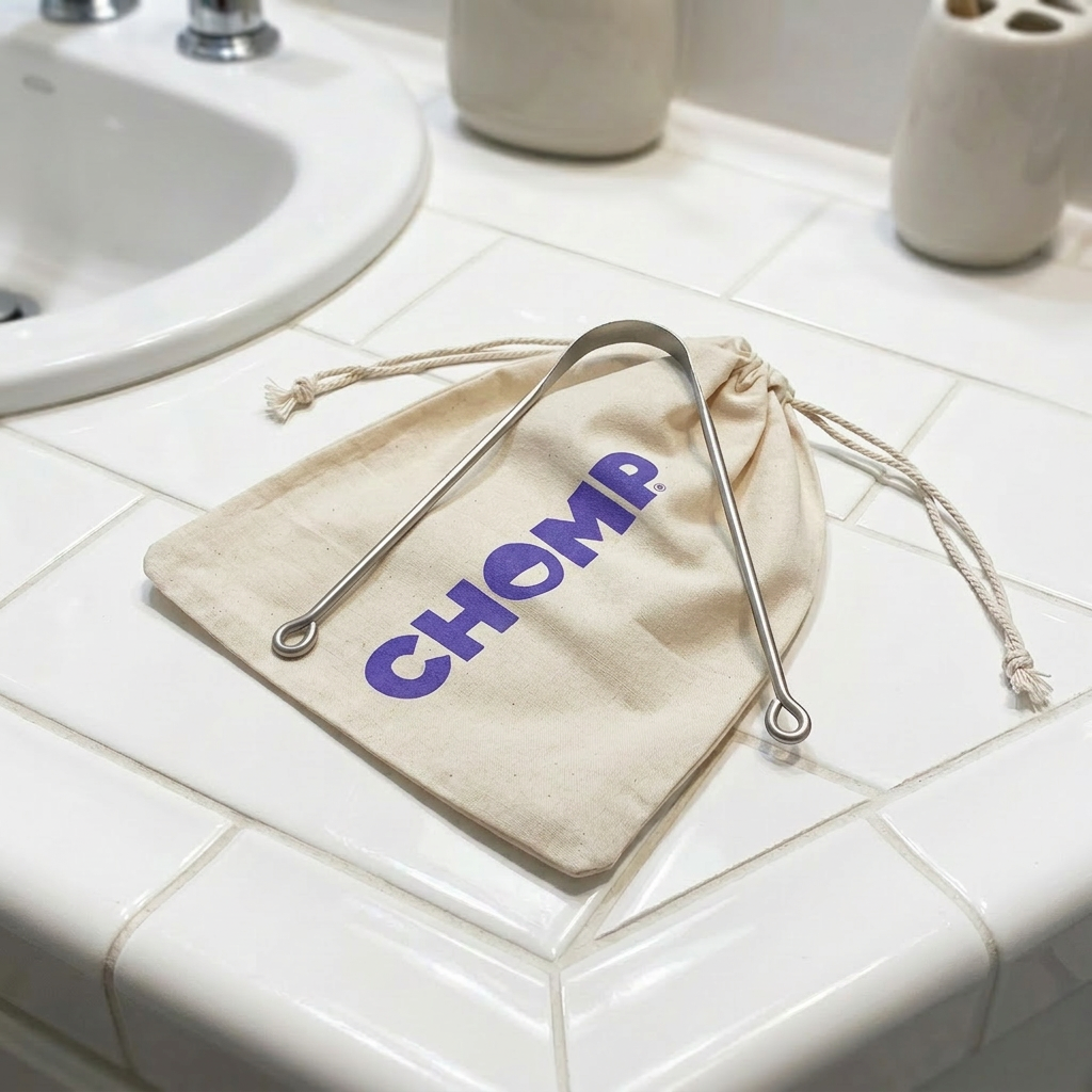 Beige drawstring bag with 'CHOMP' branding on a bathroom counter.