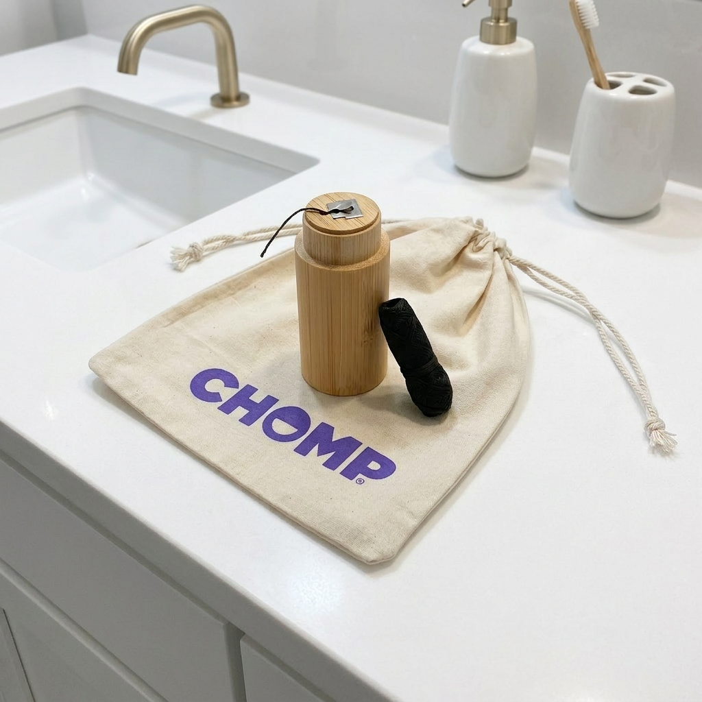 Bathroom counter with a bamboo product and drawstring bag labeled 'CHOMP'.