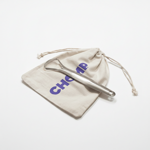 Metallic tool on a beige drawstring bag with 'Chop' branding on a bathroom counter.