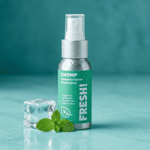 Chomp Spearmint Splash Breath Spray bottle with mint leaves and ice cube on a teal background