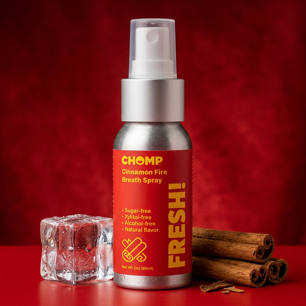 Chomp Cinnamon Fire Breath Spray bottle with cinnamon sticks and ice cube on a red background