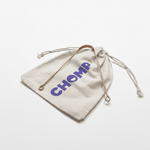 Beige drawstring bag with 'CHOMP' branding on a bathroom counter.