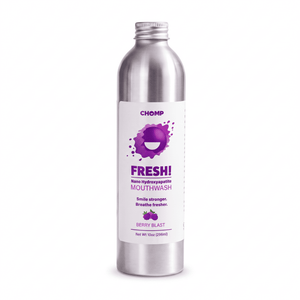 A silver metal bottle of CHOMP Fresh! Nano Hydroxyapatite Mouthwash in Berry Blast flavor, featuring a white label with purple graphics and berry illustrations, set against a plain white background.