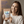 A smiling woman in a cream sweatshirt holds a stand-up pouch of NanoMints natural minty freshness mouth freshener. The background is a soft beige wall with blue promotional text on the left side.