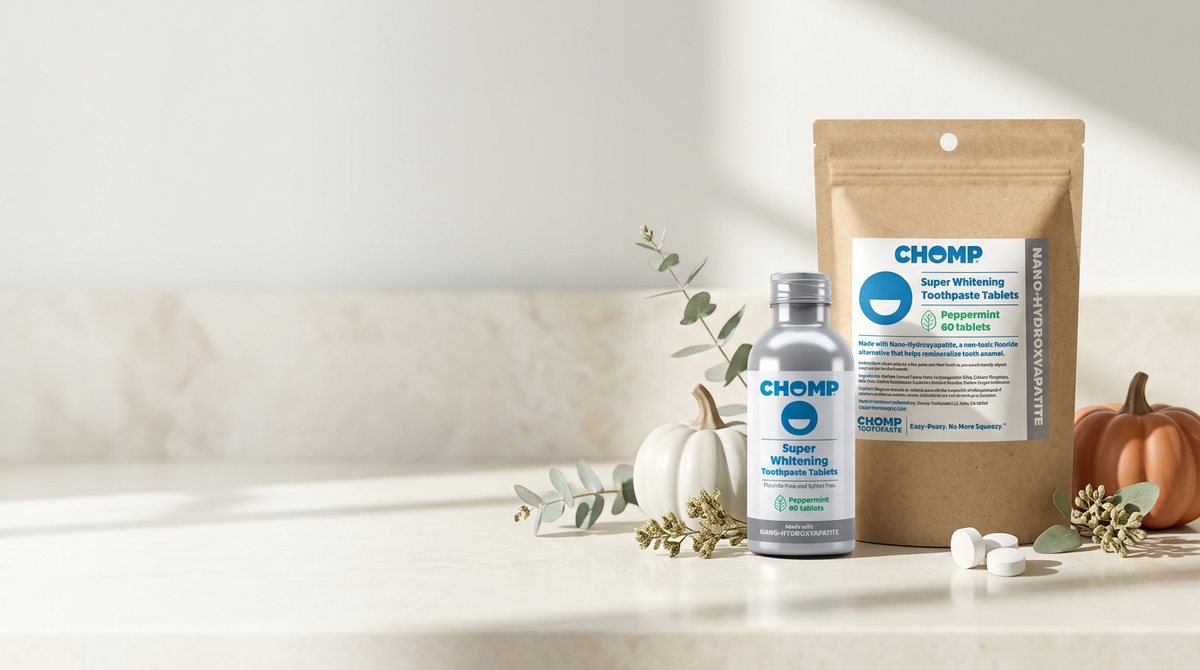 Chomp toothpaste refill and bottle surrounded by pumpkins and greenery.