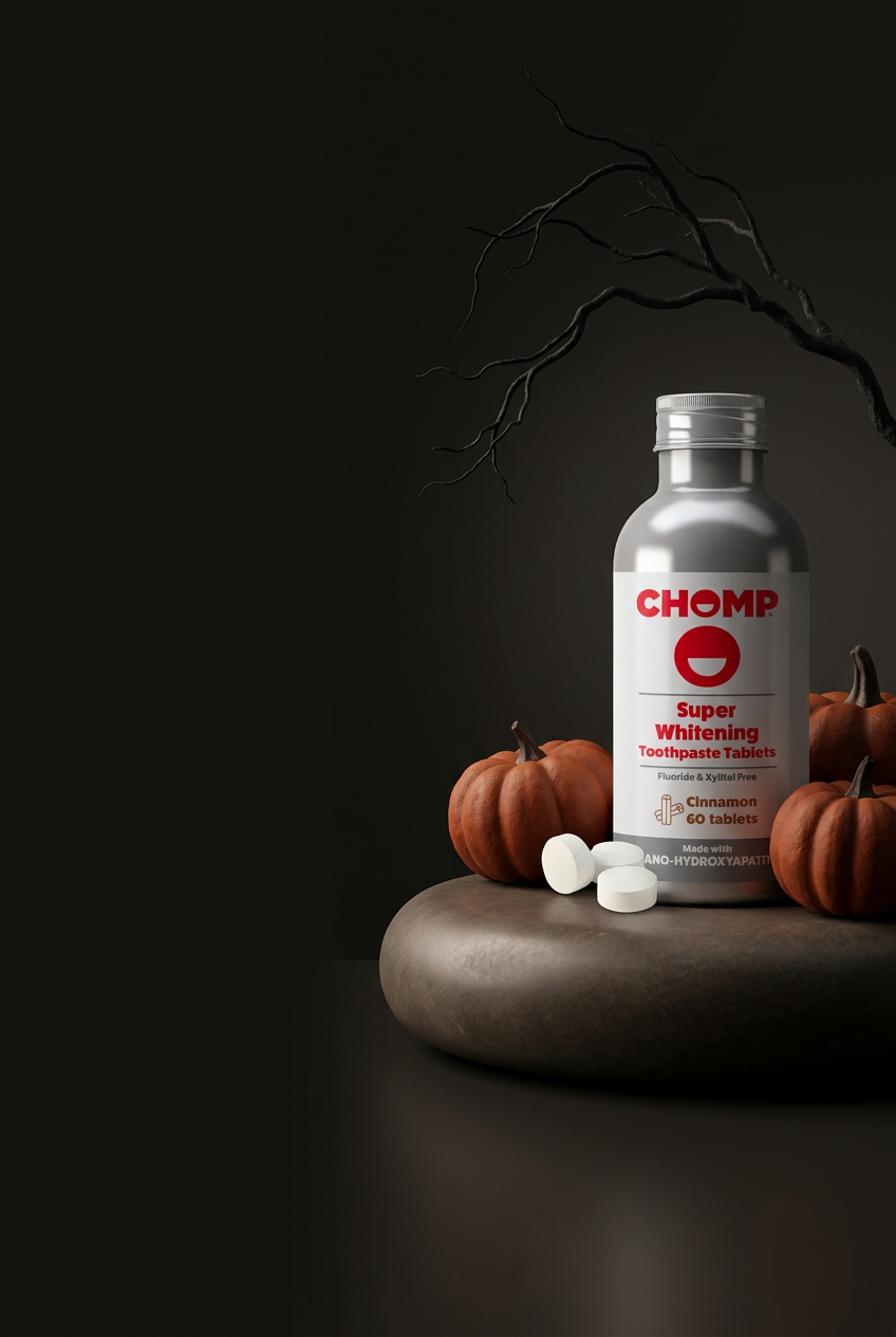Chomp cinnamon toothpaste bottle on dark background with pumpkins around it.