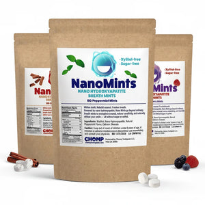 Three stand-up pouches of CHOMP NanoMints breath mints in a kraft paper packaging, with loose mints and berries displayed in front on a white background.