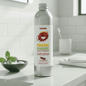 Silver bottle of Chomp Fresh Probiotic Mouthwash on a bathroom counter.