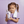 Child holding a bottle of 'Fresh!' mouthwash against a purple tiled wall