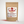 A kraft paper stand-up pouch labeled NanoMints Breath Mints stands on a white background, with three small white speckled mints placed in front of the package.