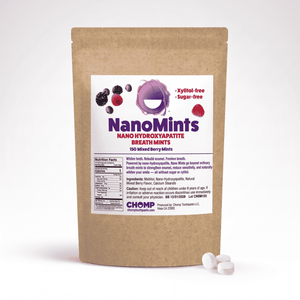 A stand-up kraft paper pouch of NanoMints breath mints with a white front label, shown on a light gray background with three white round mints in front.
