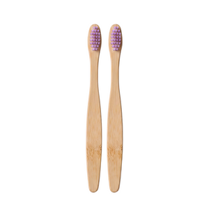 Two bamboo toothbrushes with purple bristles, arranged vertically side-by-side on a light pink background.