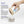 Hand holding a container of nano hydroxyapatite with product details on a white background