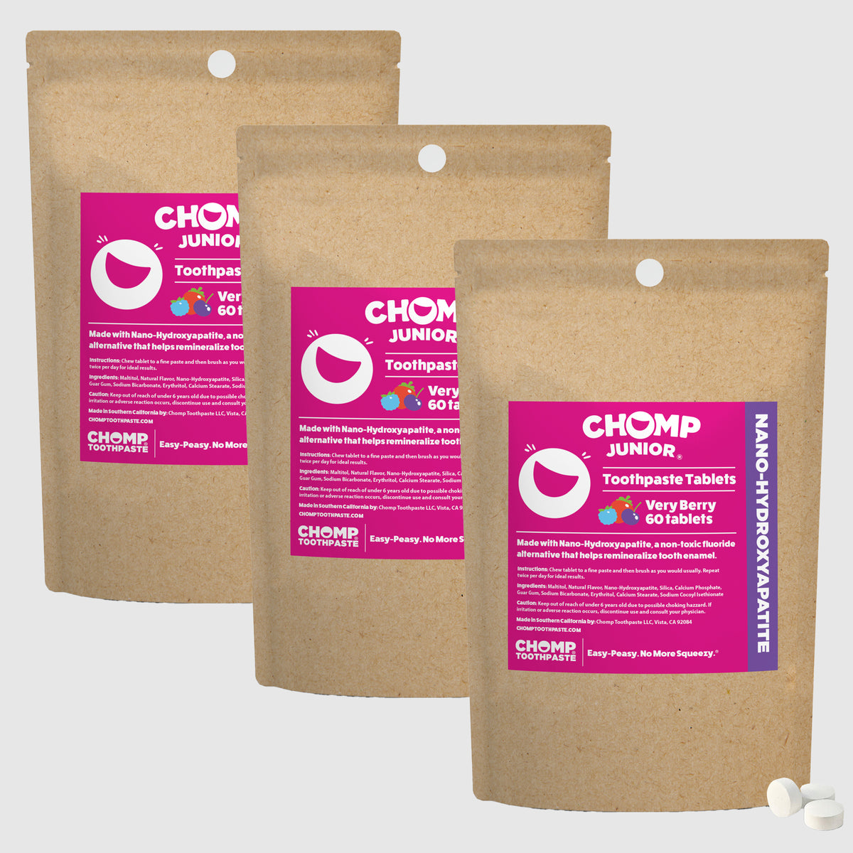 Three packages of Chomp Junior toothpaste tablets with pink labels on a white background