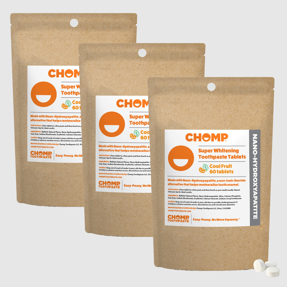 Three packages of CHOMP Super Whitening Toothpaste Tablets on a light gray background
