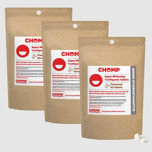 Three packages of CHOMP Super Whitening Toothpaste Tablets on a light gray background