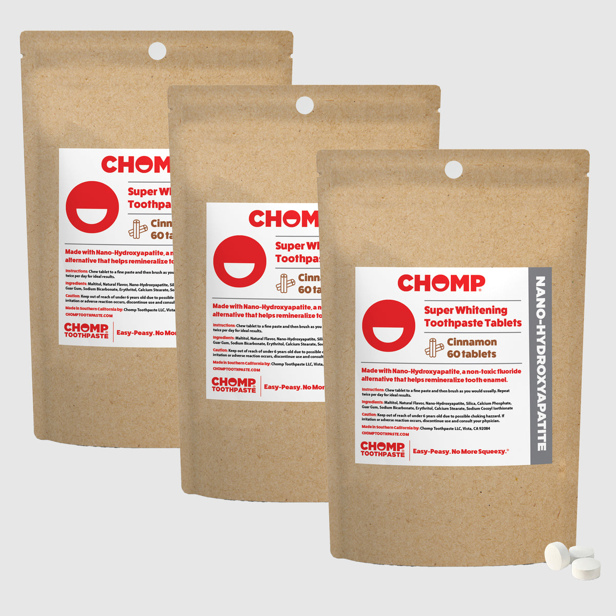 Three packages of CHOMP Super Whitening Toothpaste Tablets on a light gray background