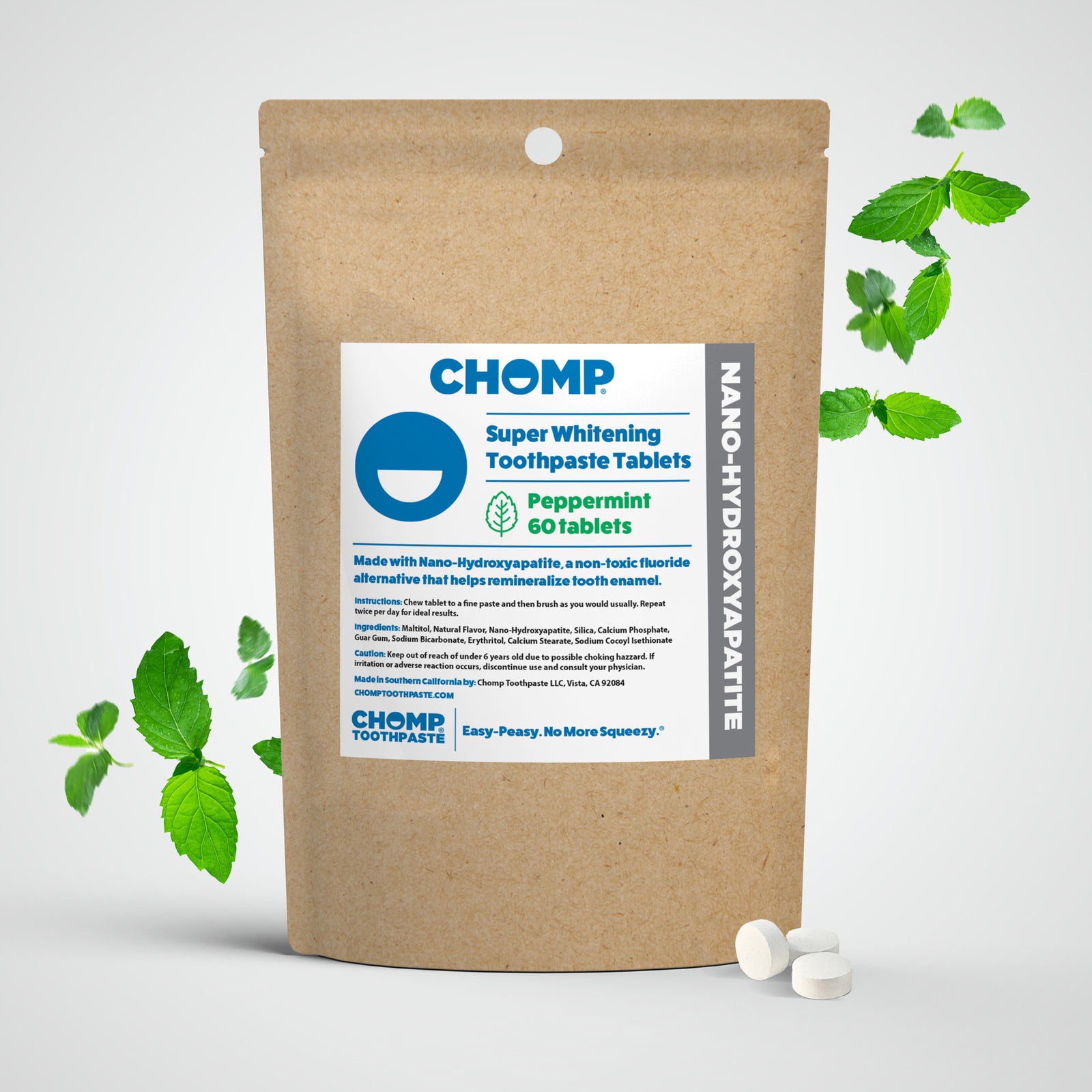 CHOMP super whitening toothpaste tablets packaging with peppermint leaves on a light gray background