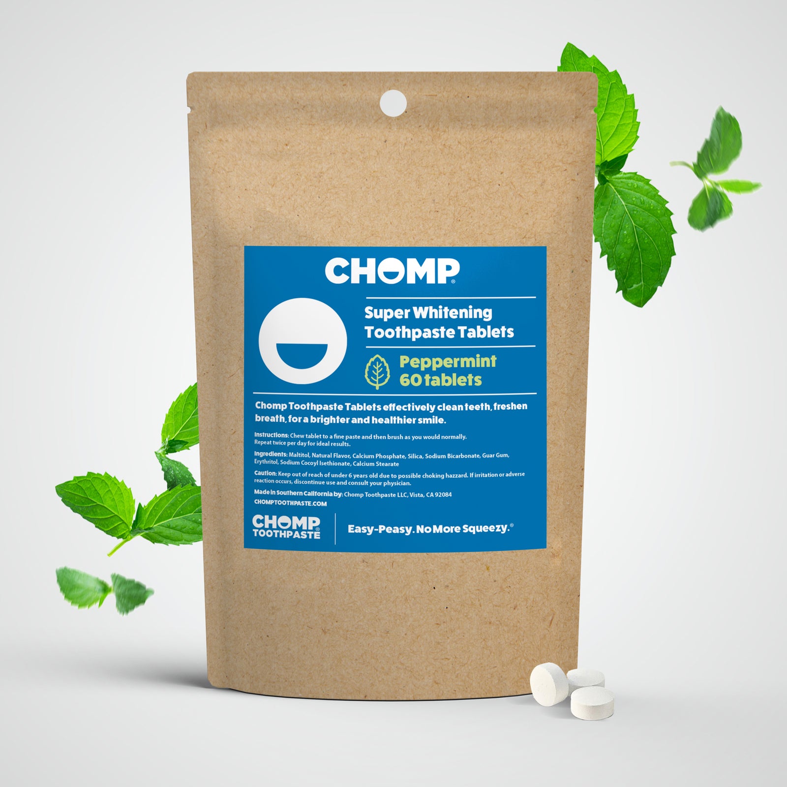 CHOMP super whitening toothpaste tablets packaging with peppermint leaves on a light gray background