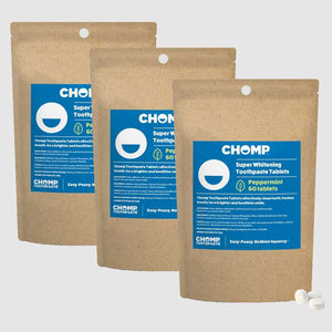 Three packages of CHOMP Super Whitening Toothpaste Tablets on a light gray background