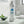 Silver bottle of FRESH! Probiotic Mouthwash on a bathroom counter with a bowl of mint leaves.