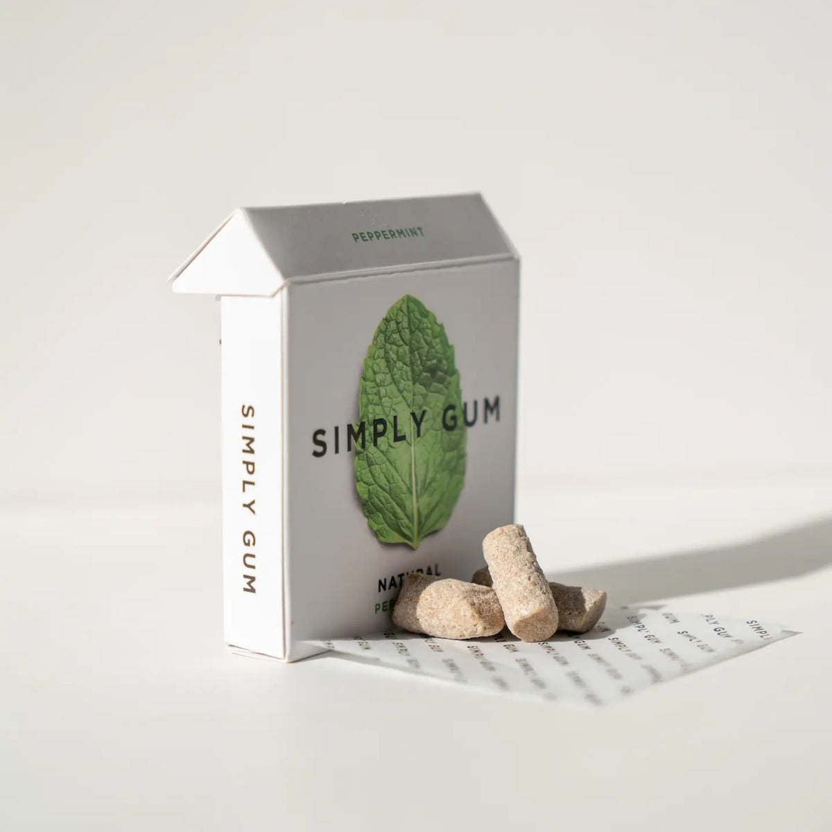 Box of Simply Gum with two pieces of gum on a white background