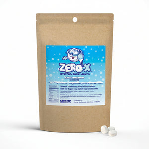A brown kraft paper stand-up pouch of Chomp Zero X Zytlol Free Mints, with a blue and white label on the front and two white round mints placed in front on a light gray background.